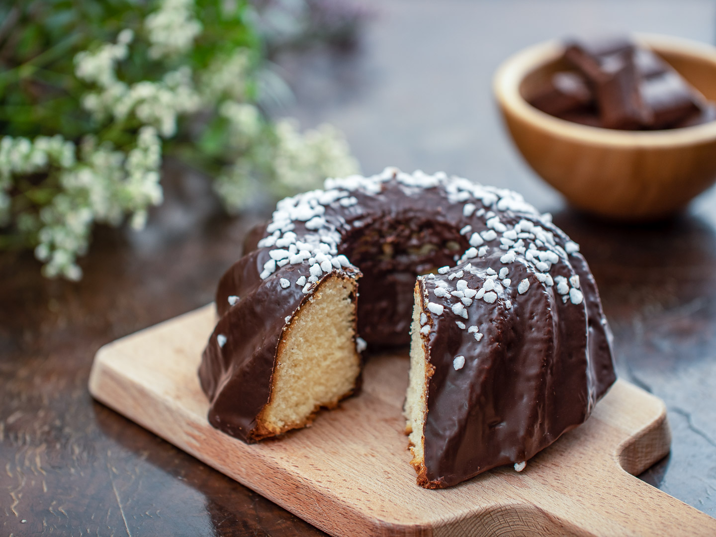 A garnished, dark-coated rustic Bundt Cake